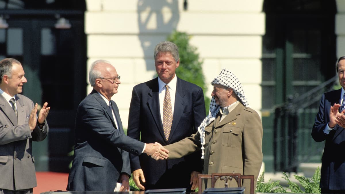 Washington D.C vuonna 1993, tuolloiset Israelin pääministeri Yitzhak Rabin, Yhdysvaltain presidentti Bill Clinton ja Palestiinan vapautusjärjestön puheenjohtaja Yasser Arafat sopimassa Oslon sopimuksesta. 
