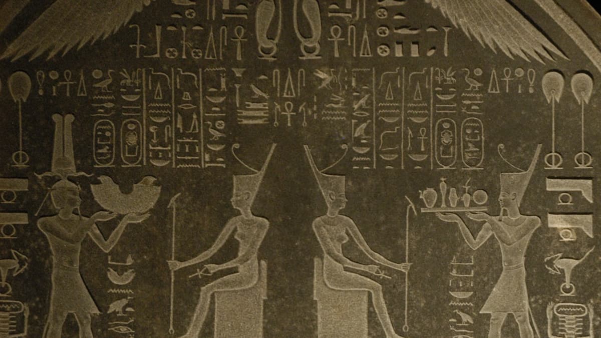 Egyptiläisiä hierglyfejä ja ihmishahmoja kivitaulussa. 