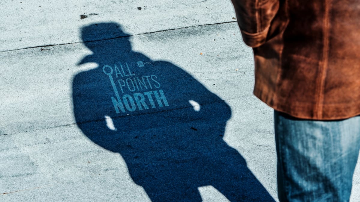 Photo of a man's shadow featuring the APN podcast logo.