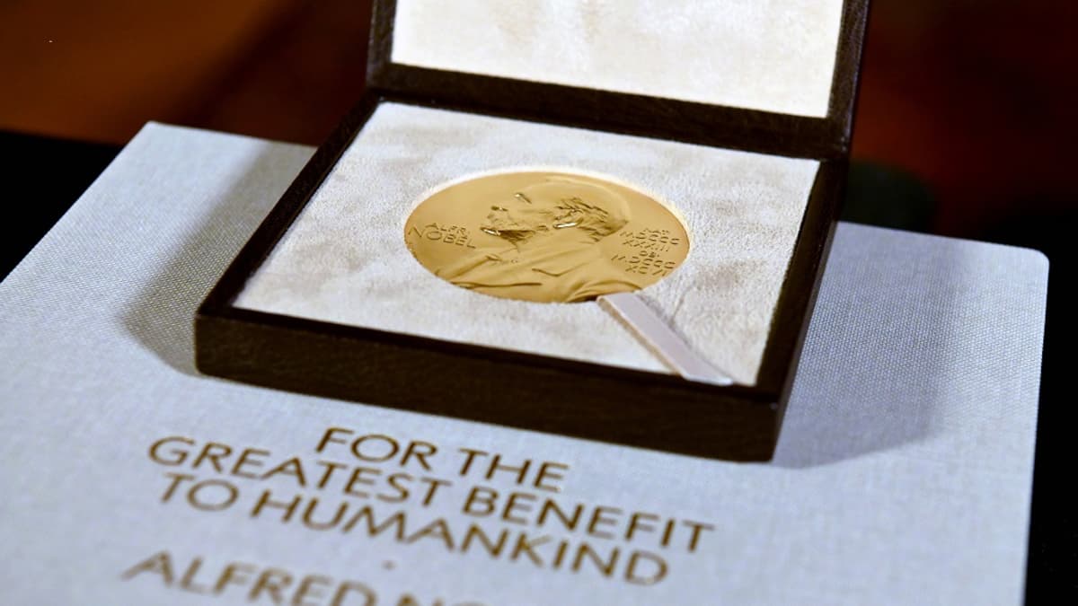 Nobel-mitali laatikossa. Alla on levy, jossa lukee englanniksi "ihmiskunnan suurimmaksi hyödyksi, Alfred Nobel"