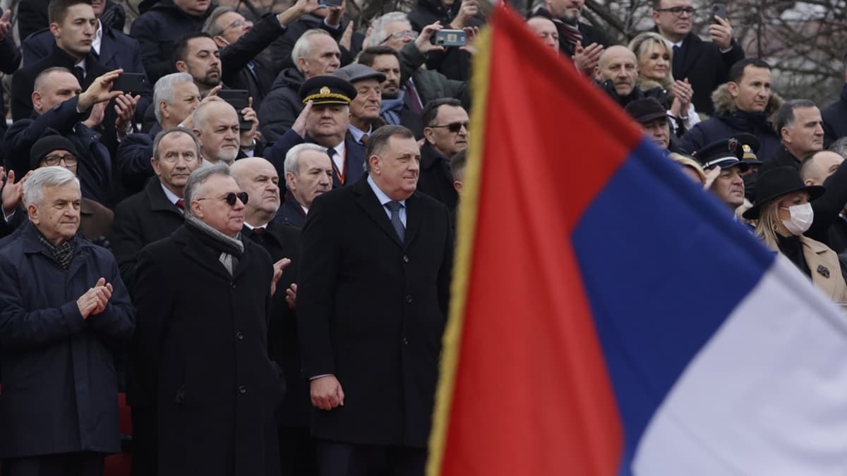 Kuvassa etualalla näkyy serbitasavallan lippu. Sen takana yleisöä, jonka keskellä seisoo Bosnian serbijohtaja Milorad Dodik. 