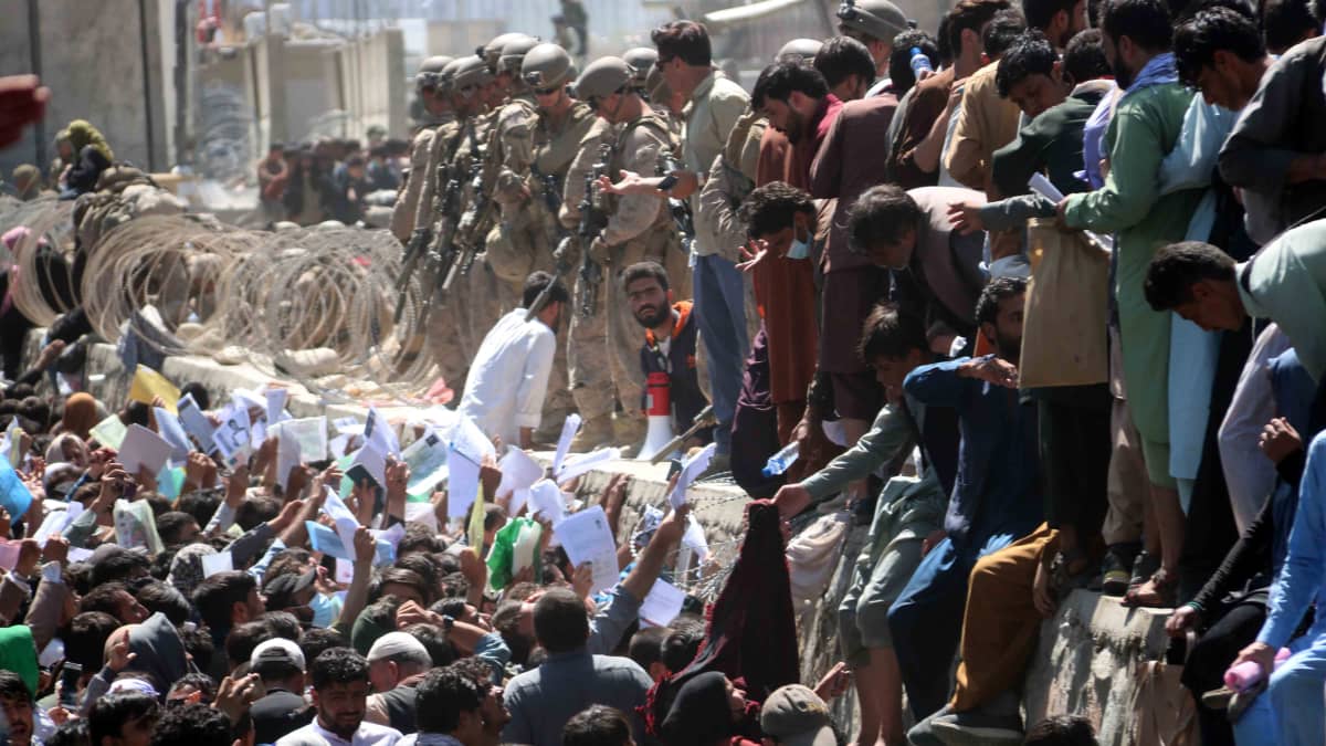 Väkijoukko yrittää rynniä Kabulin lentokentälle elokuussa 2021. 