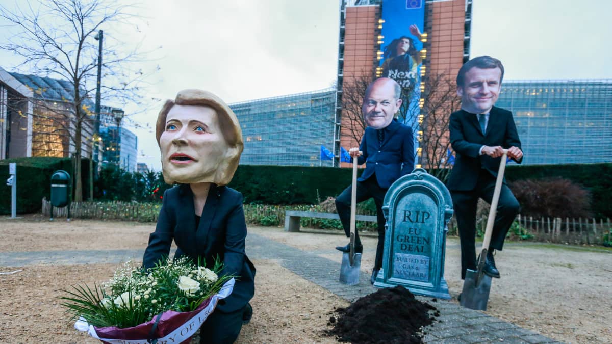 Macroniksi, Scholziksi ja von der Leyeniksi naamioituneet mielenosoittajat EU-komission edessä. Heillä on muun muassa hautakivi, jossa lukee "Lepää rauhassa EU:n Green Deal".