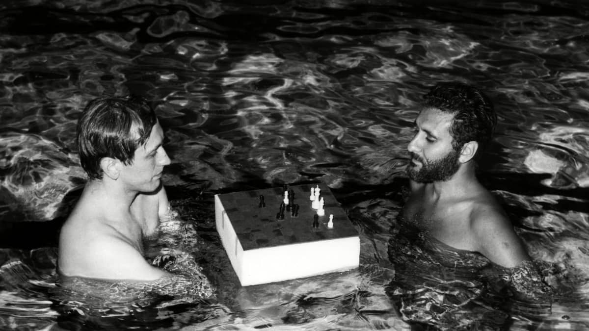 Fischer ja Larry Evans pelaavat shakkia uima-altaassa.