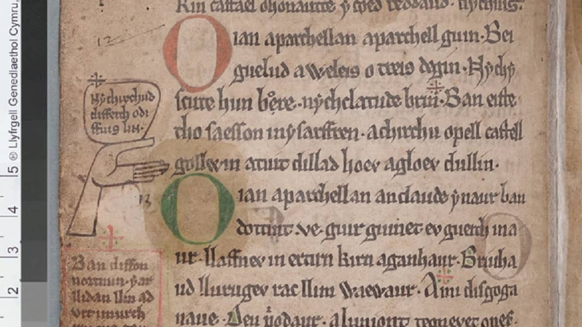 Kymrinkielinen keskiaikainen käsikirjoitus. Marginaalissa kuva ojennetusta kämmenestä. 