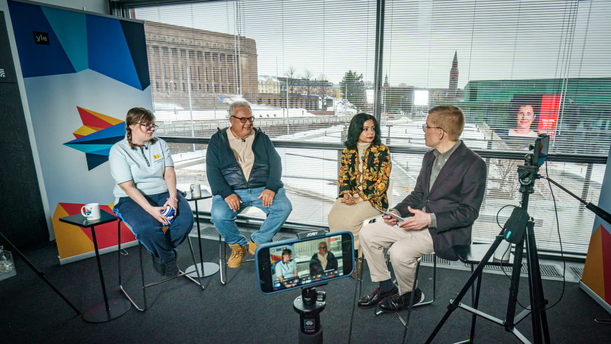 Kaksi naista ja kaksi miestä istuu ja keskustelee.