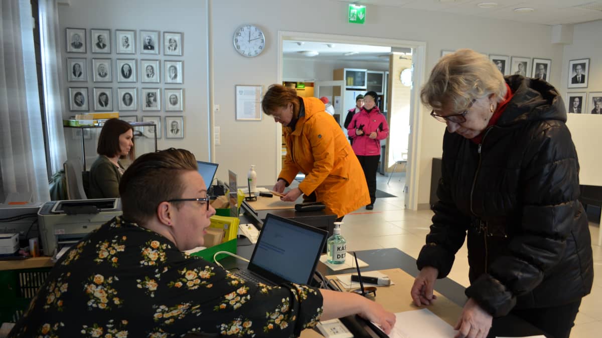 Äänestäjiä ja vaalivirkailijoita äänestyspaikalla.