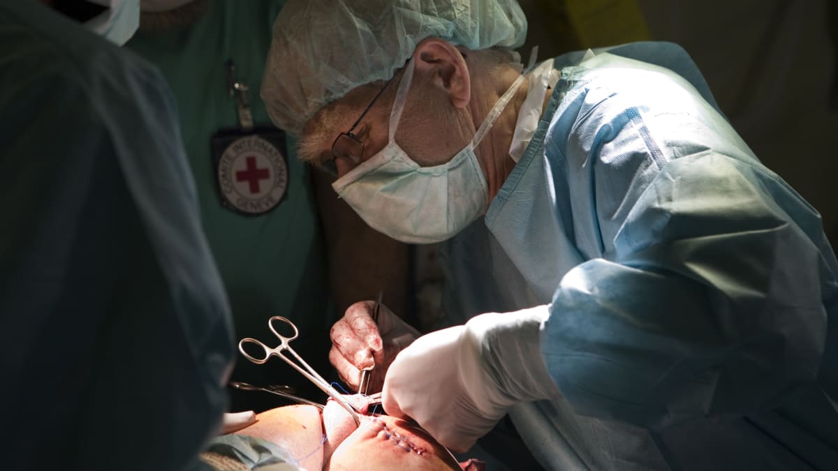 Sotakirurgi Jorma Salmela suorittaa leikkausta.