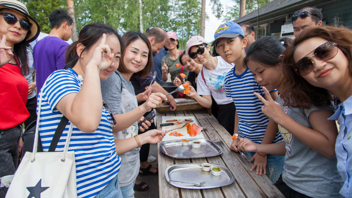 Kiinalaiset turistit nauttivat tuoreesta lohesta Imatran Vuoksen kalastuspuistossa