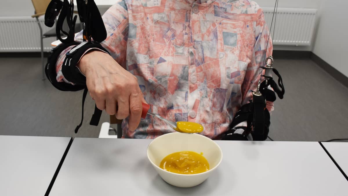 Kuvassa potilas harjoittelee syömistä robottiavusteisesti