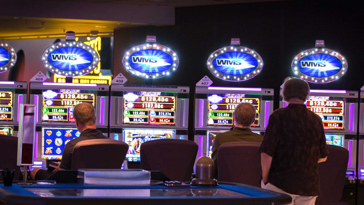 Anonyymejä ihmisiä pelaamassa rahapelejä Casino Helsingissä.