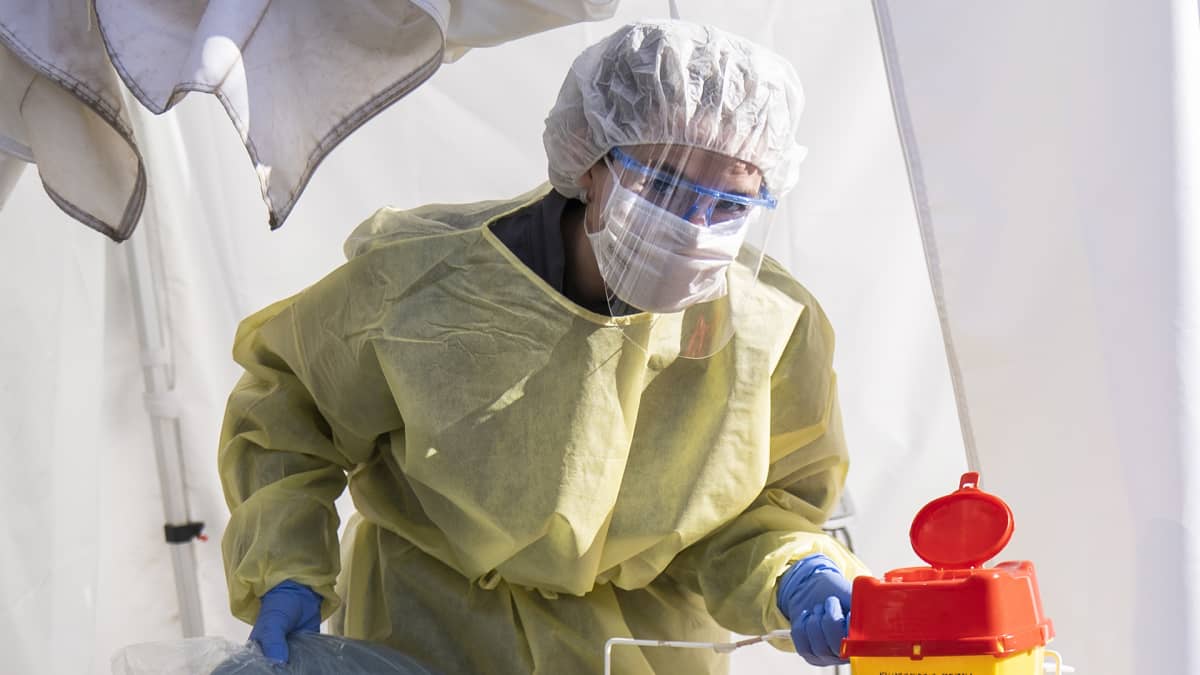 Hoitaja purkaa kenttälaboratoriota päivän päätteeksi Mehiläisen drive in koronatestauspaikalla.