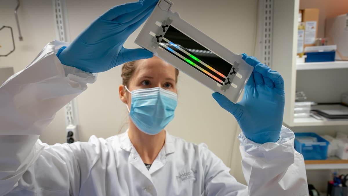 Tutkija Sari Hannula tarkastelee läpivirtauskammiota FIMMin laboratoriossa.