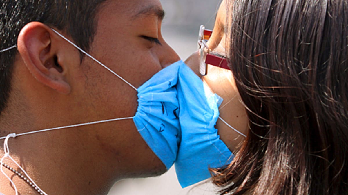 Nuori pariskunta suutelee hengityssuojamista huolimatta Méxicossa 26. huhtikuuta.