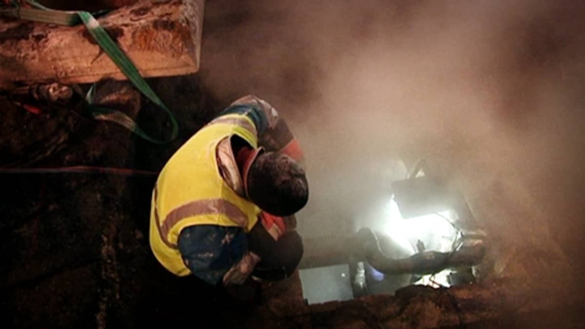 Työntekijät korjaavat kaukolämpöputkea yöllä.