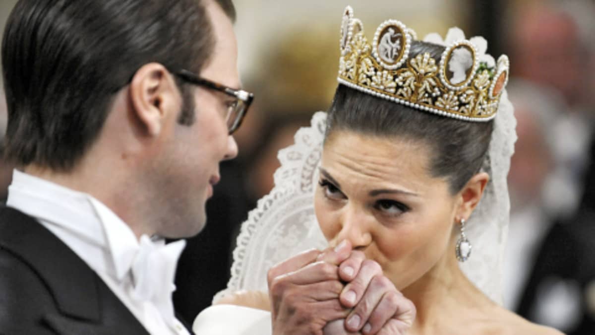 Kruununprinsessa Victoria suutelee tuoreen aviomiehensä kättä Tukholman suurkirkossa.