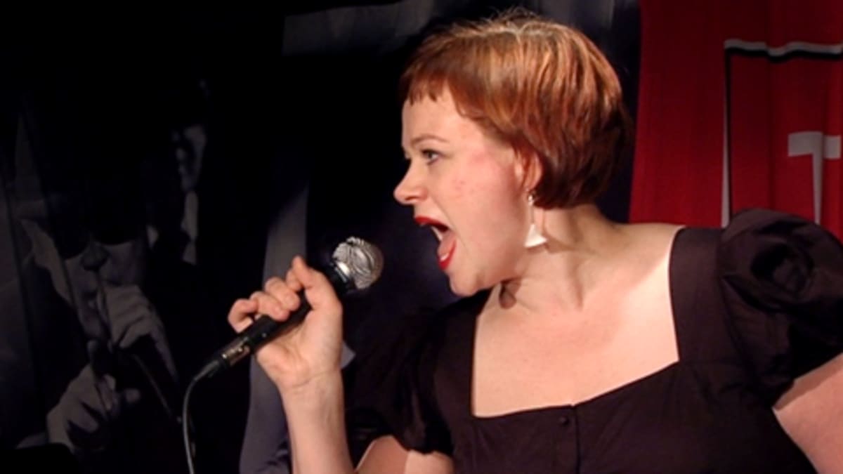 Paula Lehtomäki laulaa karaokea.
