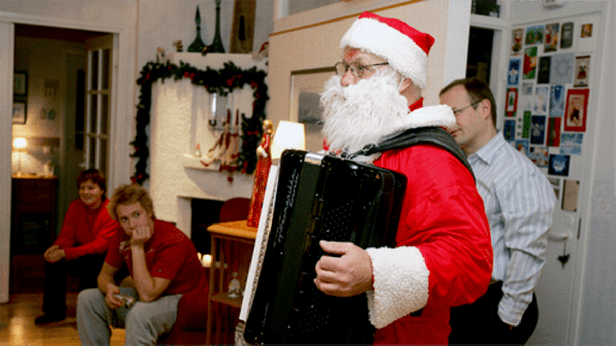 Joulupukki soittaa haitaria perheelle jouluaattona.
