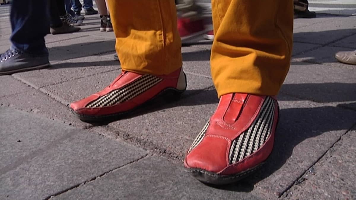 Värikkäät miesten kengät kadulla.