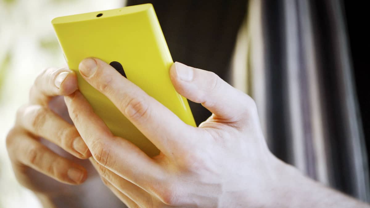 Mies selaa Nokia Lumia 920 -älypuhelinta.