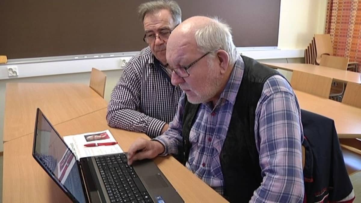 Kouluttaja ja opiskelija tutkivat nettisivuja tietokoneelta