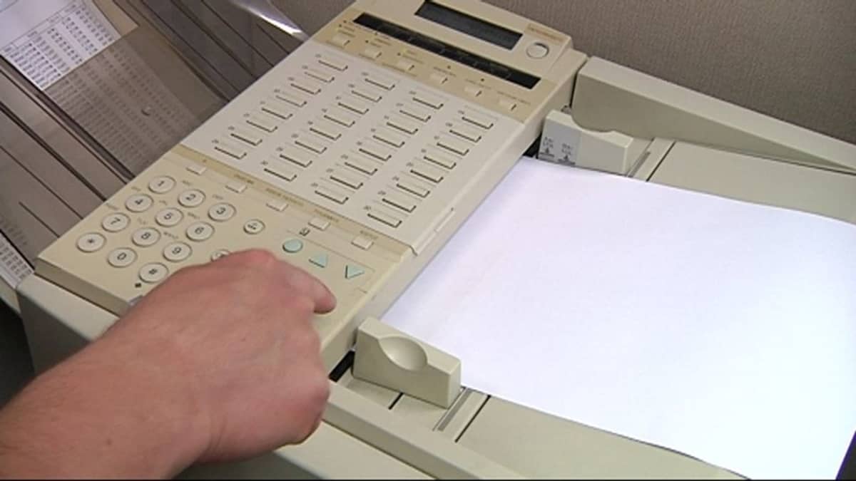 Mies näppäilee faksin numeroita.