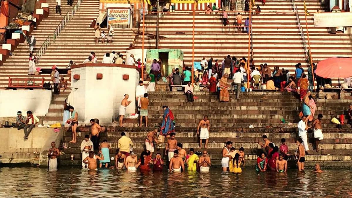 Ihmiset kylpevät Gagnesissa, Varanasin kaupungissa.  Ihmisiä on myös taustalla näkyvilla portailla.