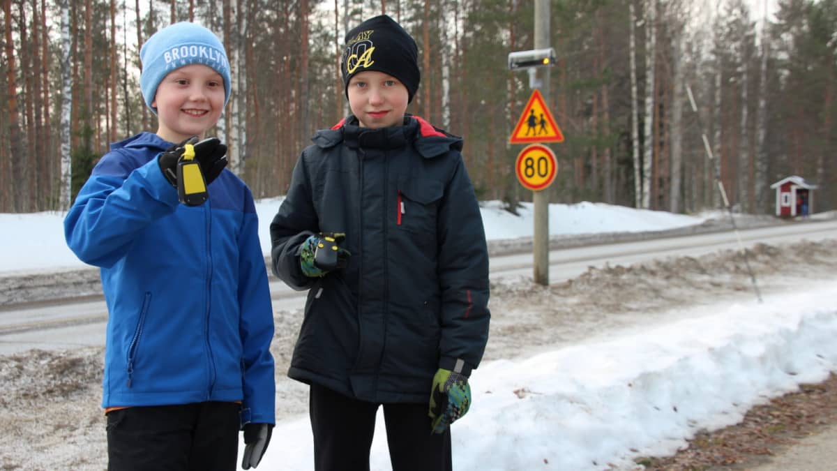 Salokylän koulun oppilaat Altti Mononen ja Jousia Hatunen esittelevät lähettimiä, jotka aktivoivat koululaisista varoittavan vilkkuvalon.