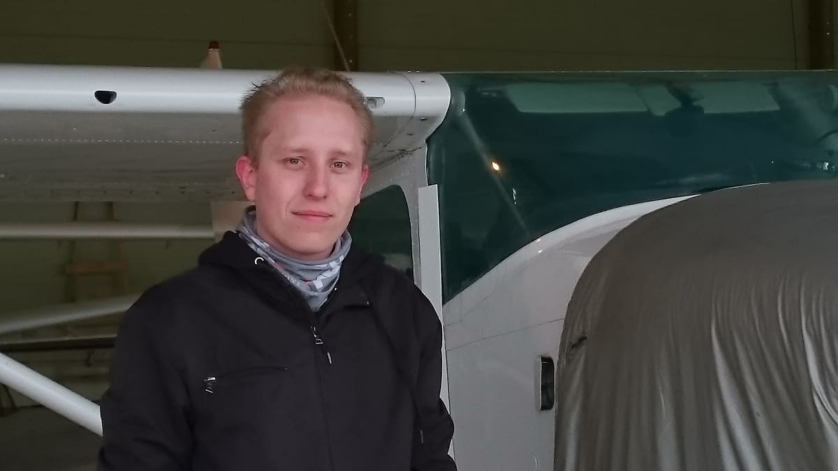 Skydive Jyväskylän puheenjohtaja Esa-Matti Suuronen seisoo kerhon lentokoneen vieressä.