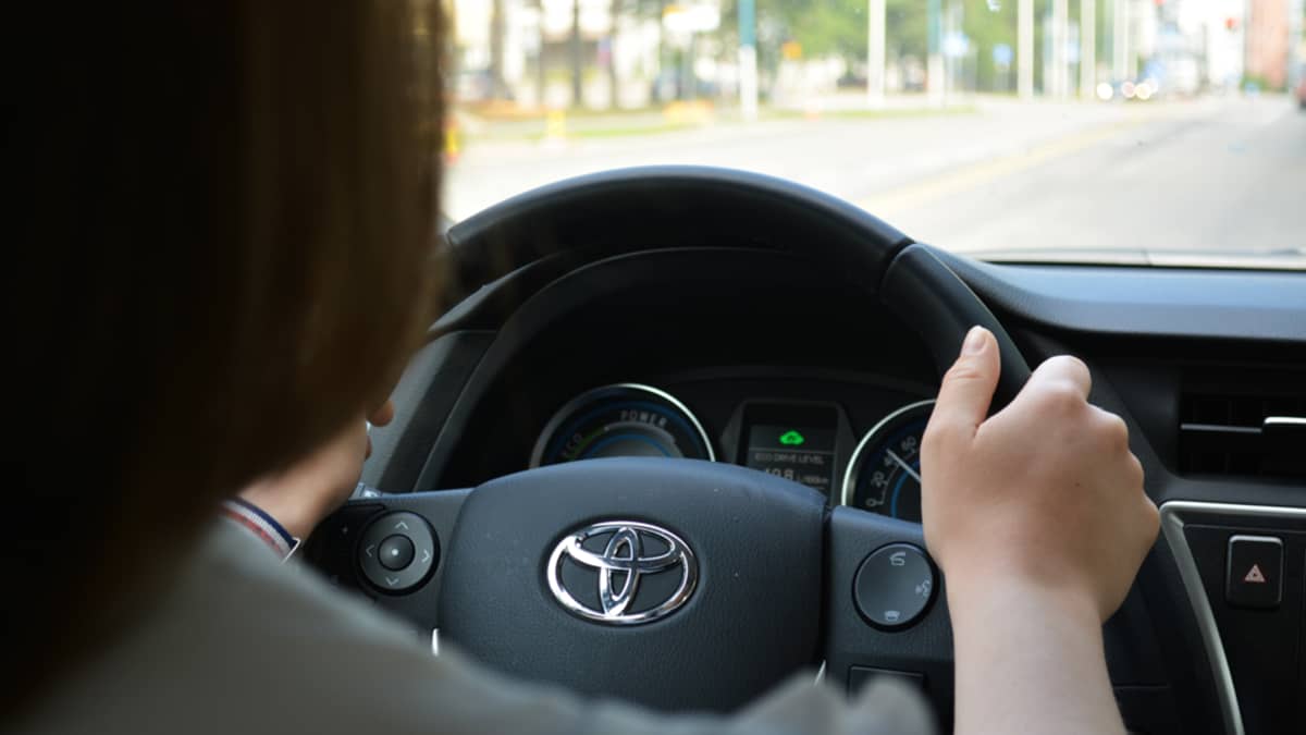 Nainen ajaa autolla.