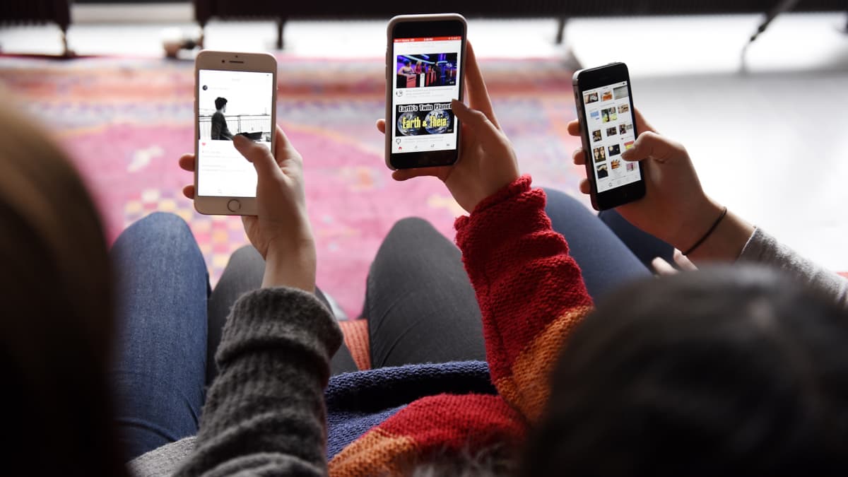 Nuoret tutkivat kännyköitään.