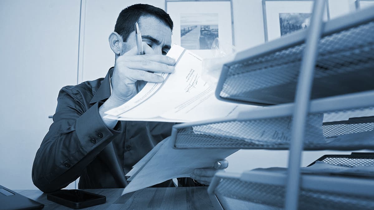 toimistotyöläinen selaa papereita