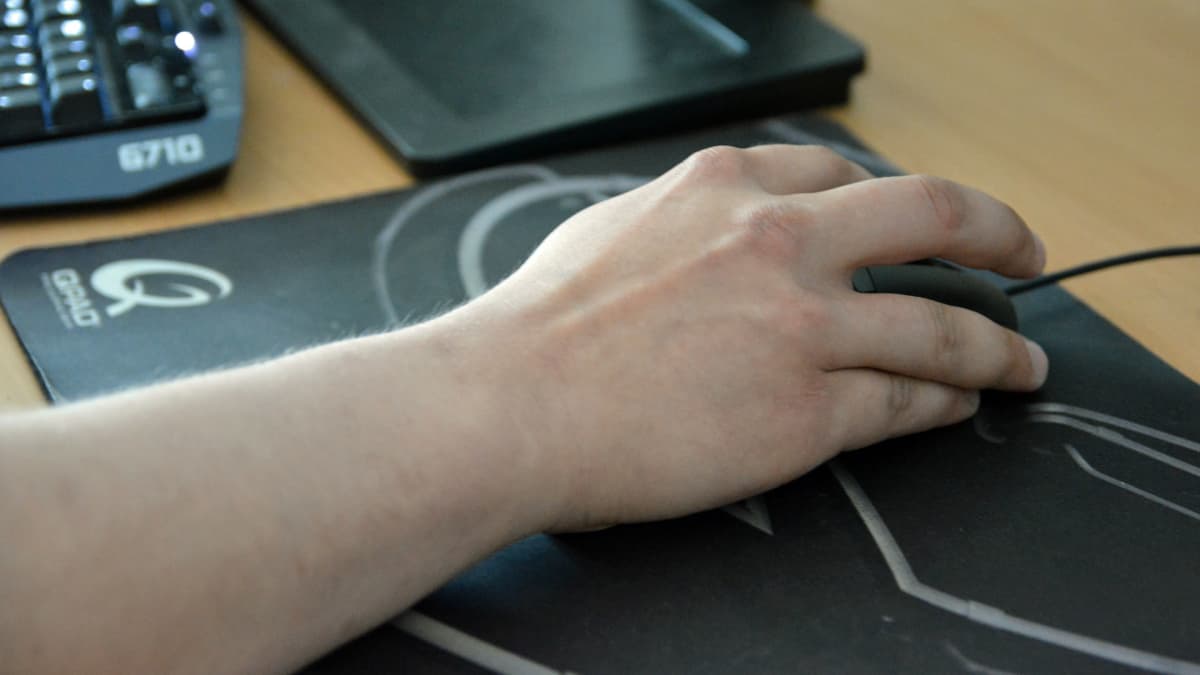 Käsi liikuttaa tietokoneen hiirtä.