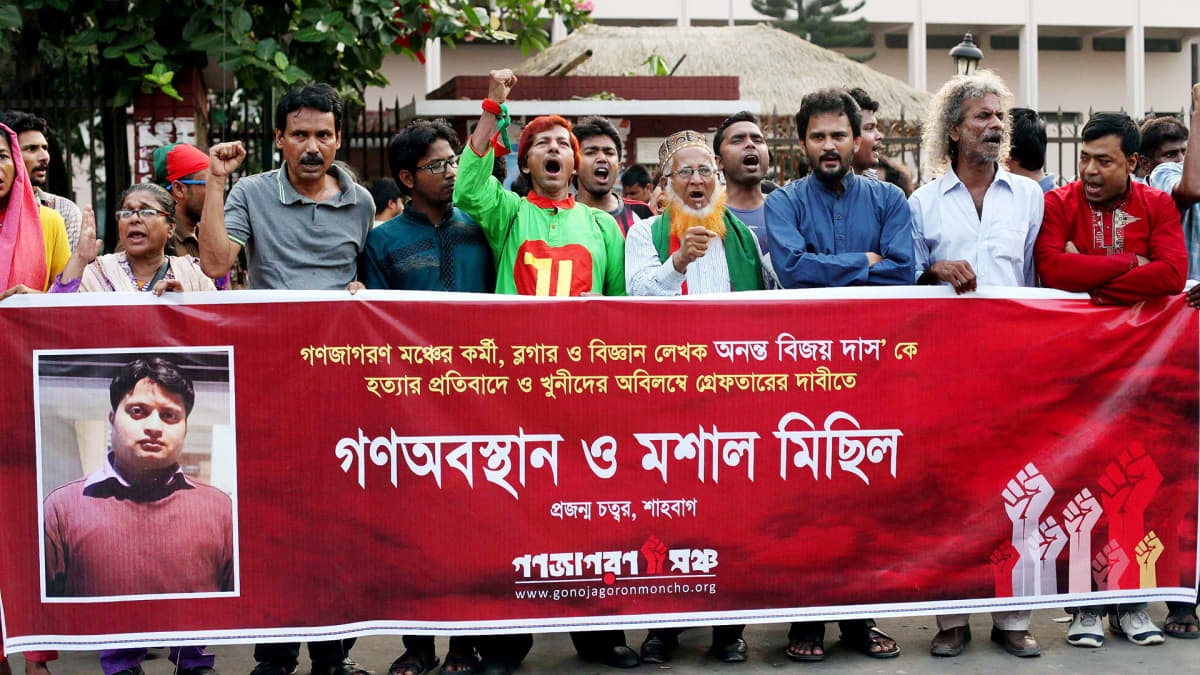 Mielenosoittajia, edessä iso banneri ja  Ananta Bijoy Dasin valokuva.