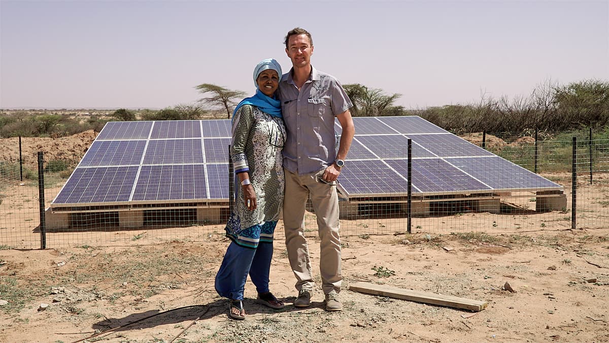 Leila Omar ja Mika Häikiö asentamansa aurnkovoimalan edustalla Somalimaassa.