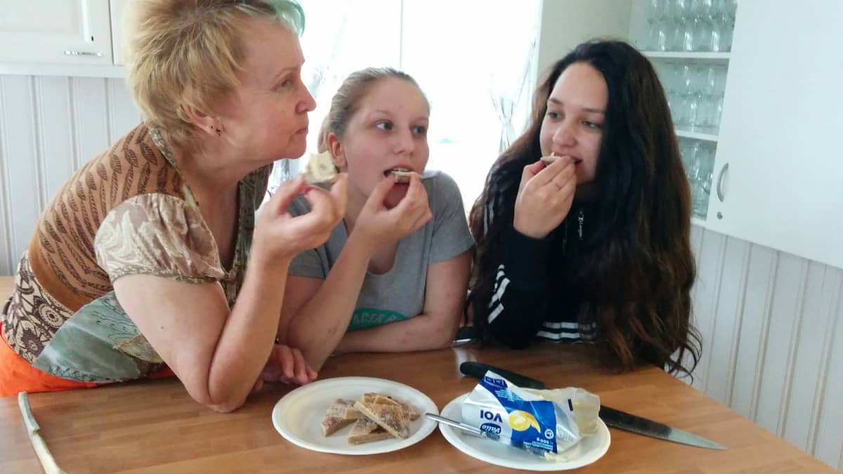 Anna Mäki-Paavola ja lastenlapset naurisleipää syömässä.