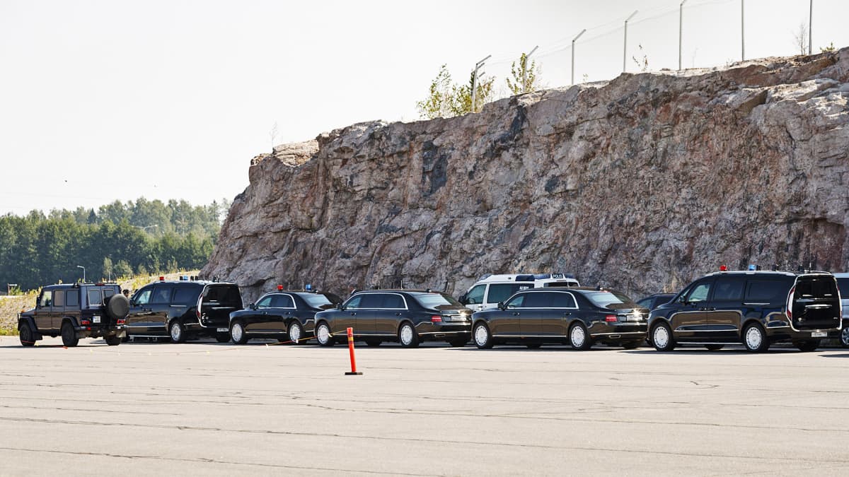 Mustat autot odottavat lentokentällä Vladimir Putinin koneen saapumista.