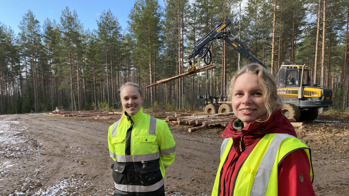 Hämeen ammattikorkeakoulun metsäalan opiskelijat Reetta Huovinen ja Miia Makkonen metsässä moton edessä Lammin Evolla.