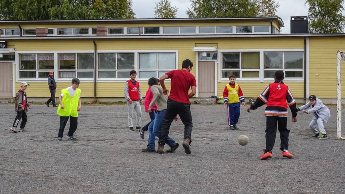 Oppilaita koulupihalla pelaamassa jalkapalloa