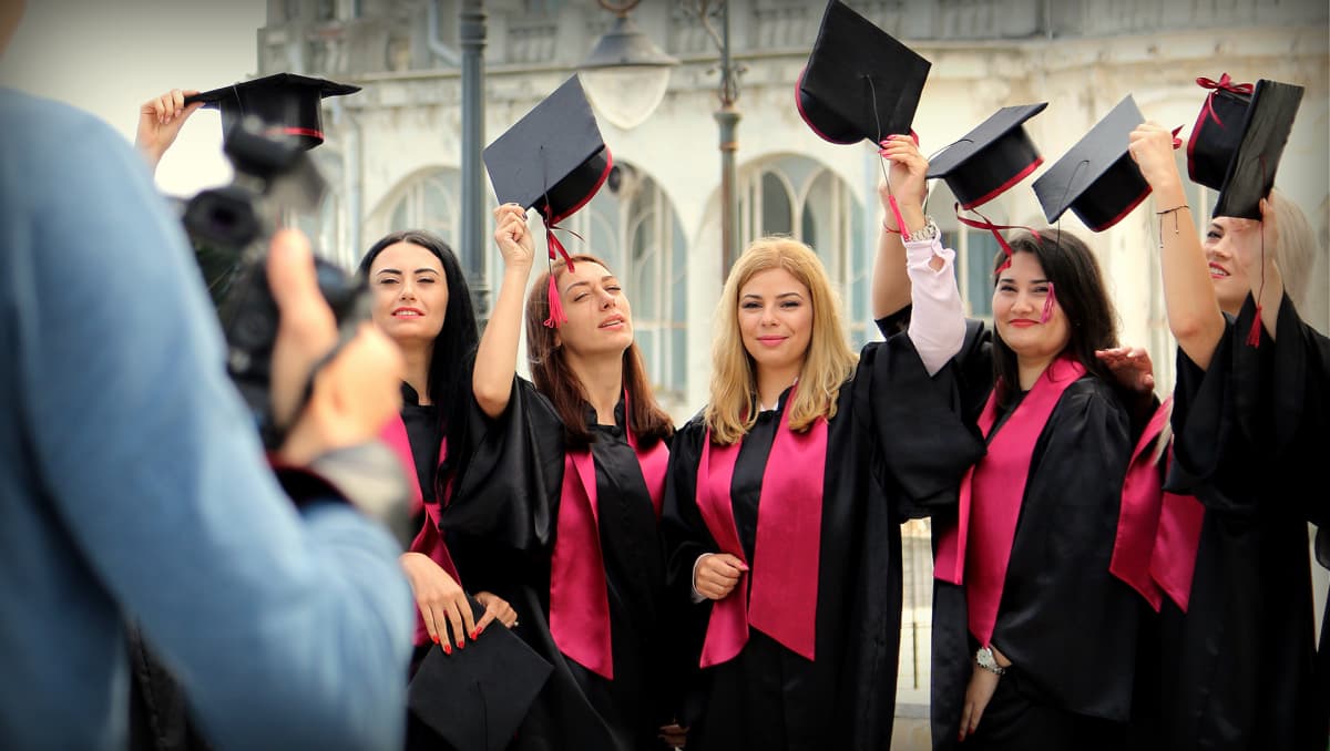 Irina Pican (keskellä) unelmoi hammaslääkärin urasta Yhdysvalloissa. Naiset juhlivat yliopiston päättäjäisiä Constantan satamakaupungissa Romaniassa.