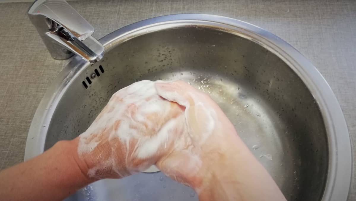 Nainen pesee käsiään.