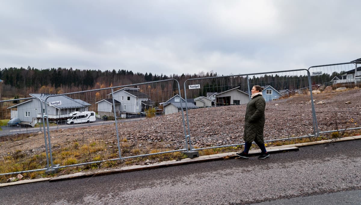 Minna Ruolanto kävelee tyhjän tontin vieressä, josta asunnot purettiin.