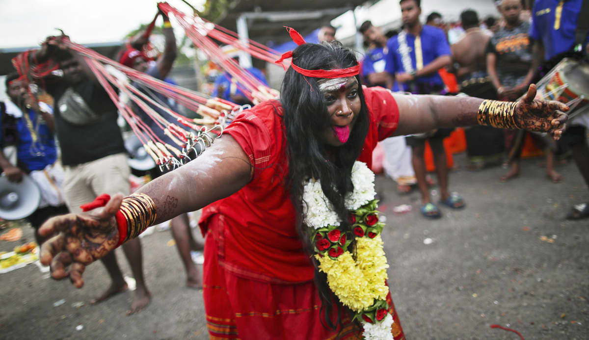 Harras hindunainen transsitilassa Thaipusam-festivaalin kulkueessa.