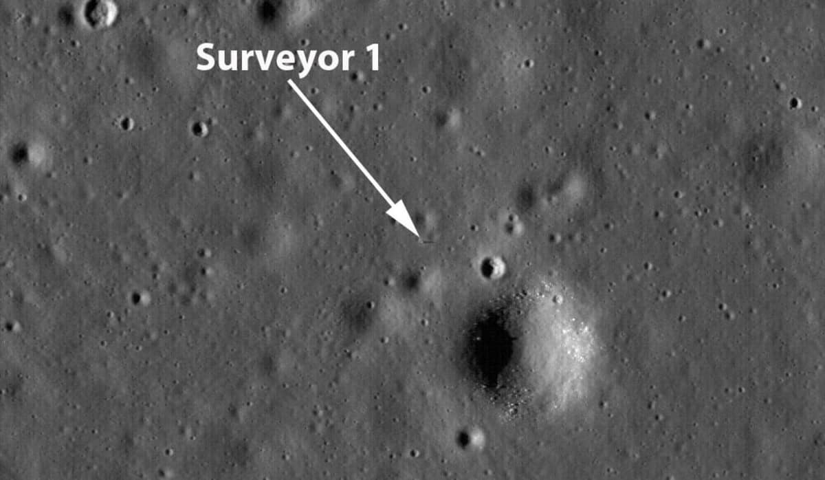 Nuoli osoittaa pientä pistettä Kuun kraatterien ja kumpujen välissä. 
