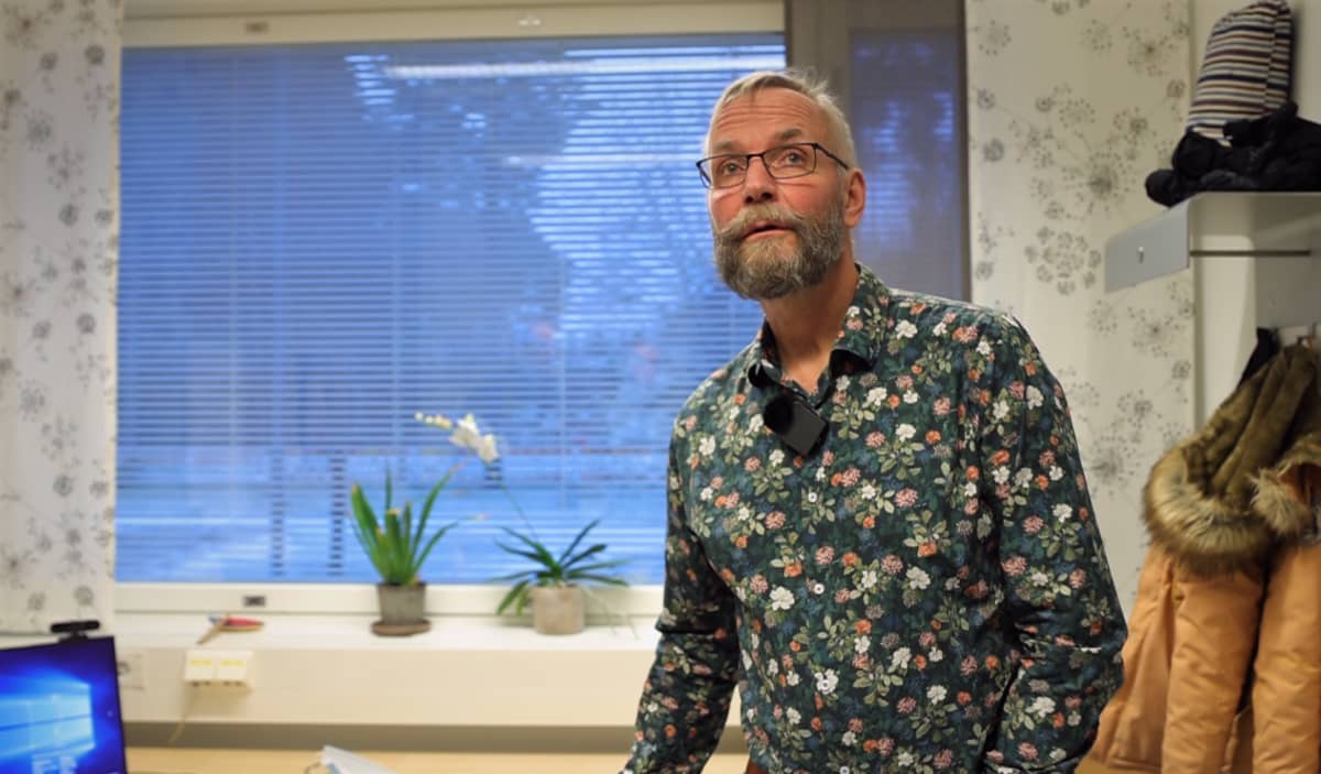 Juha T. Karvonen, nuorisopsykiatrian erikoislääkäri seiso toimistossa ja katsoo ylös.  