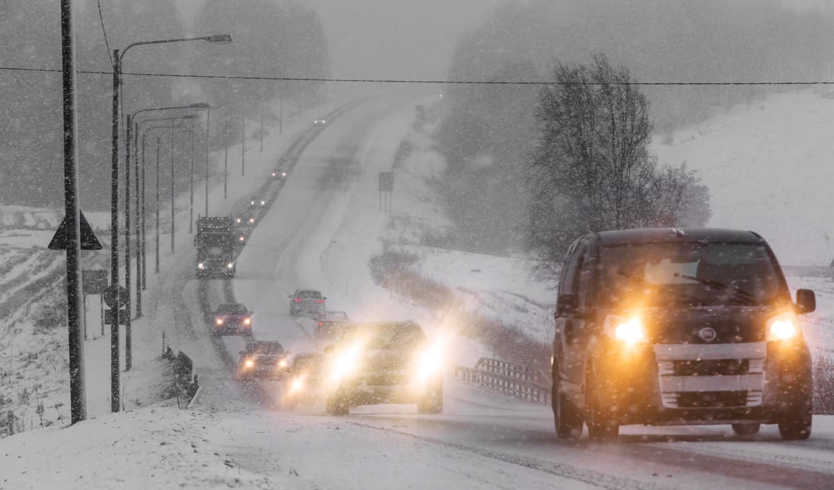 Autoja maantiellä lumisateessa.