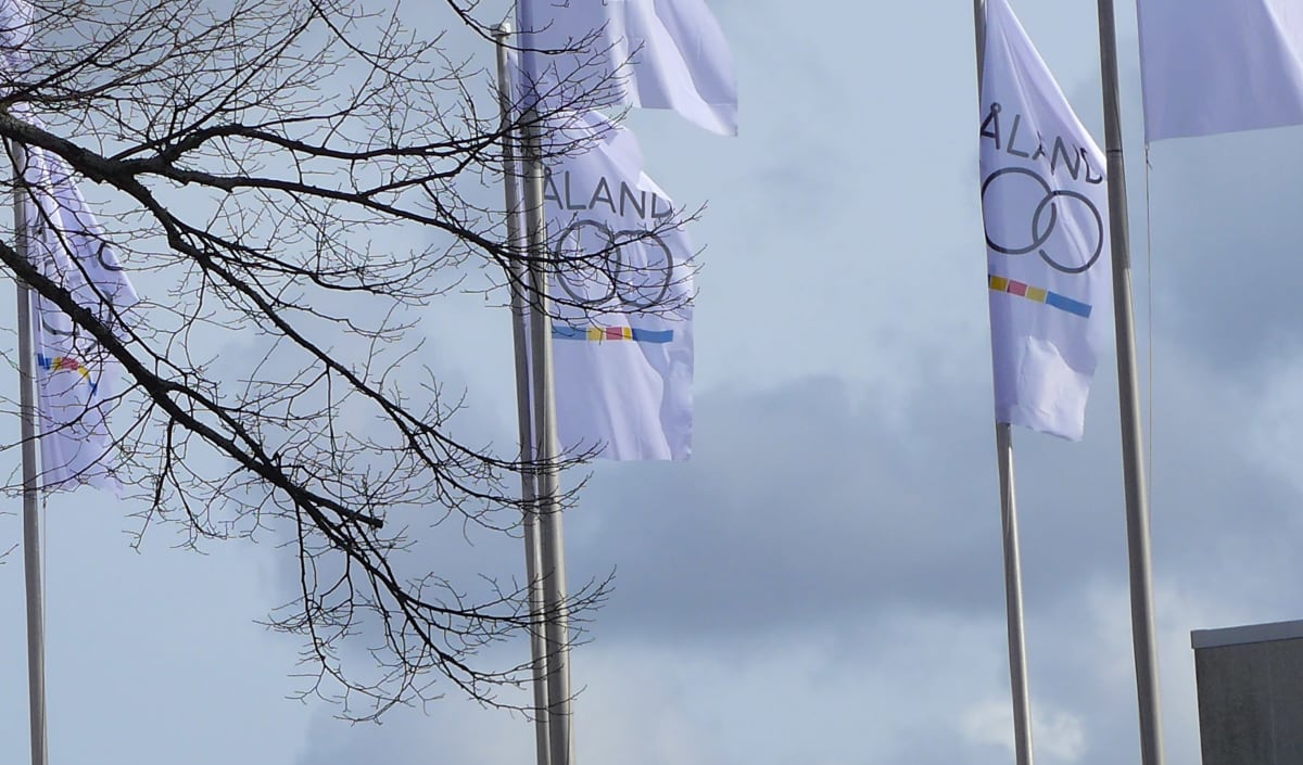 Ahvenanmaan 100-vuotista itsehallintoa juhlistavat liput Landskapstyrelsenin edustalla Maarianhaminassa.