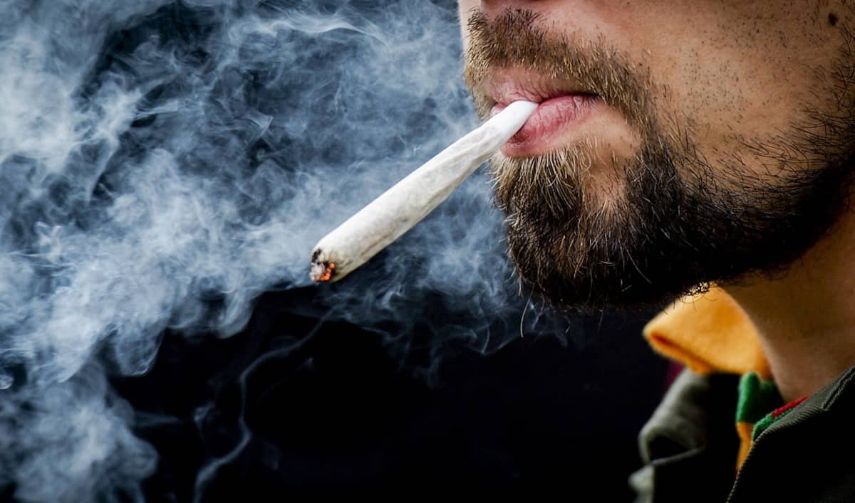 Mies polttaa kannabista.