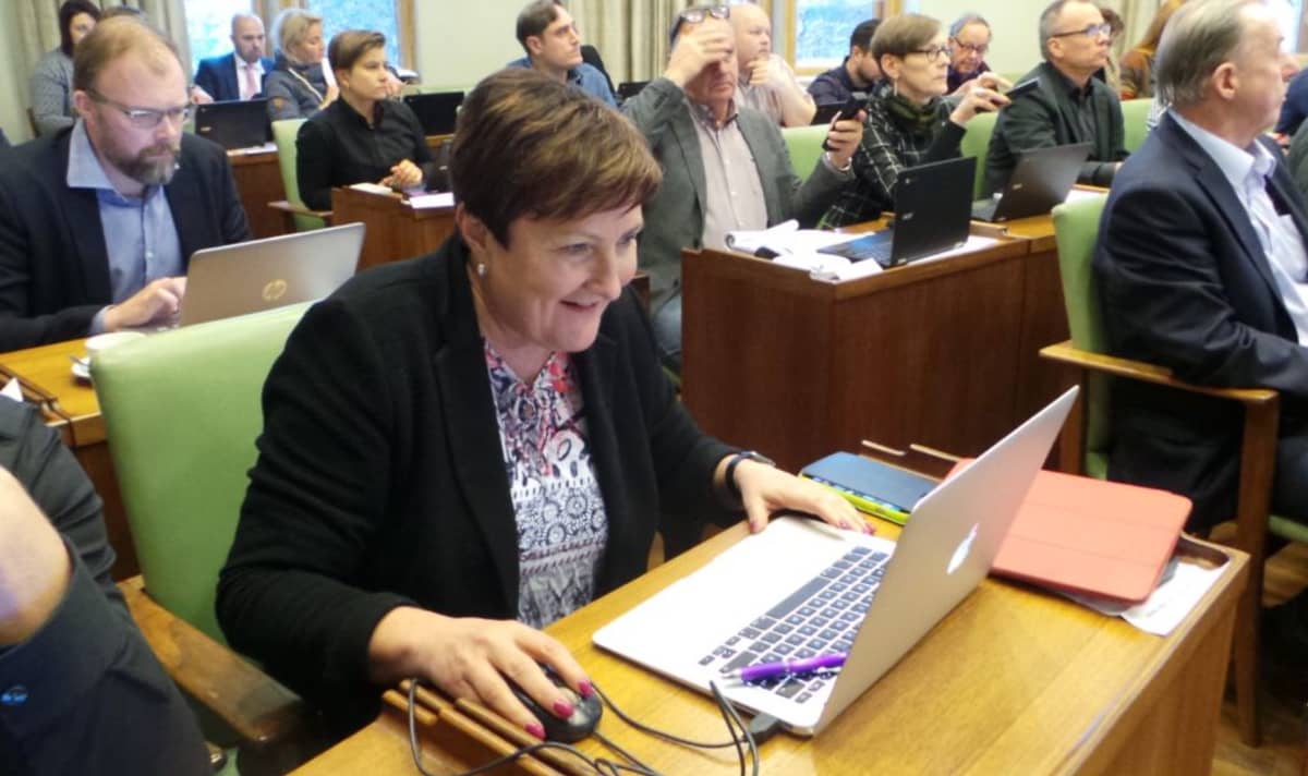 Porin kaupunginjohtaja Aino-Maija Luukkonen Porin valtuustossa 13.11.2017, katsoo tietokonetta, on iloinen.