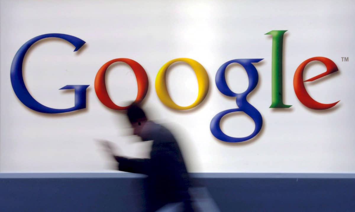 Mies kävelee Googlen logon editse